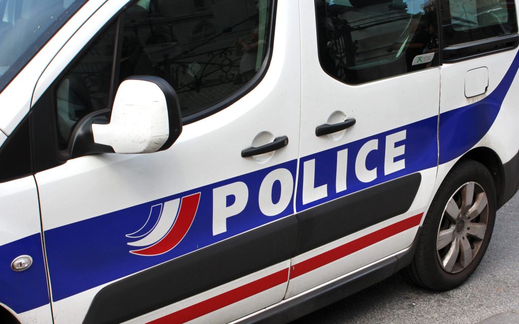 Vue rapprochée d'un véhicule de police avec l'inscription "POLICE" sur le côté.