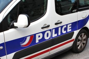Vue rapprochée d'un véhicule de police avec l'inscription "POLICE" sur le côté.
